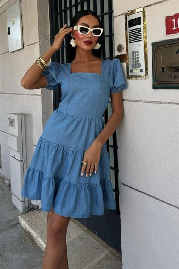 Chic and playful in a blue ruffled dress, paired with bold accessories and stylish sunglasses