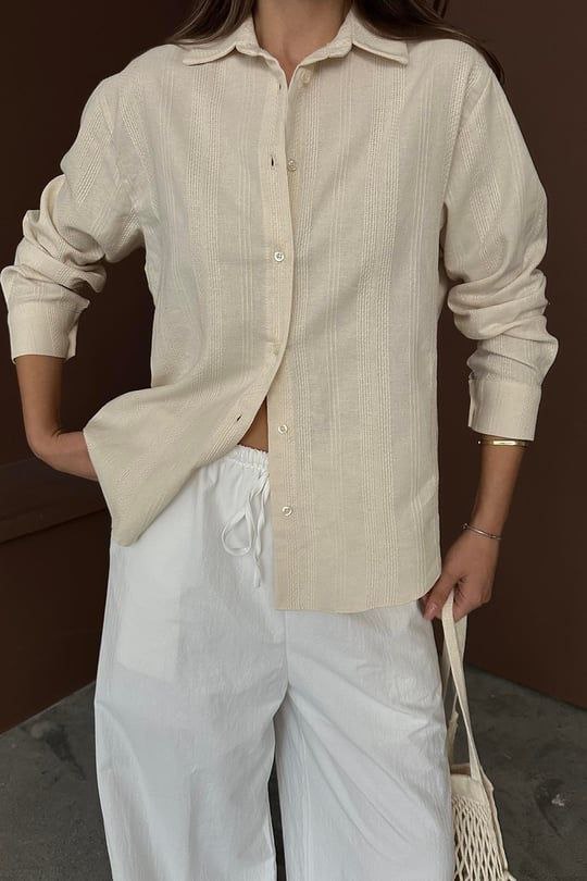 "A classic off-white shirt, featuring a soft neutral tone that blends elegance with versatility. Perfect for both formal and casual wear, made from lightweight, breathable fabric for all-day comfort."